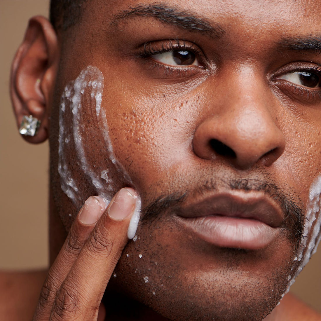 Man scrubbing his face as part of his skincare routine.