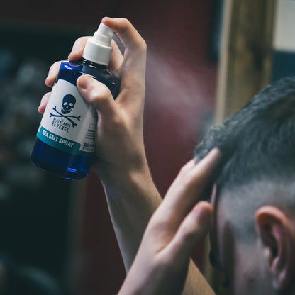 The Bluebeards Revenge vegan friendly sea salt spray being sprayed into a man's hair in a barbershop